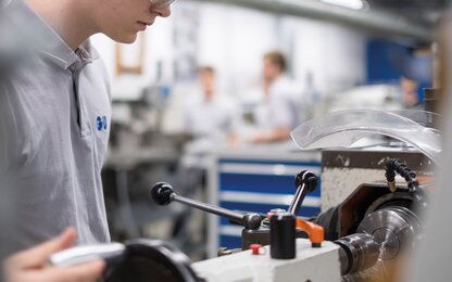 Mitarbeiter in der Fertigung – Präzision und handwerkliches Können Junger Mitarbeiter bei der Arbeit in der Produktion von Werkzeugen und Beschlägen, mit Fokus auf Präzision, Fertigungstechnologie und handwerkliches Geschick.