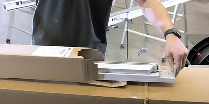 Vorkonfektionierte GU-Systembodenschwelle Person, die eine vorkonfektionierte Bodenschwelle aus einem Aufreißkarton entnimmt