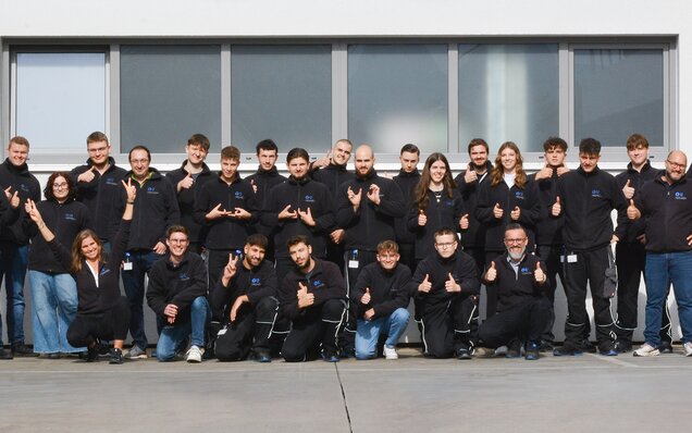 Teamfoto vor Firmengebäude mit Daumen hoch Gruppenfoto eines Teams vor einem Gebäude mit Daumen-hoch-Gesten