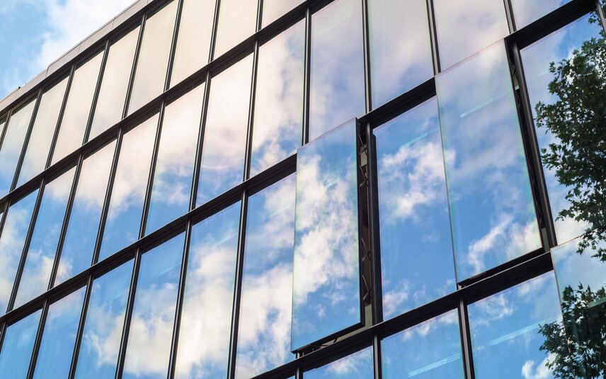 Moderne Glasfassade mit geöffneten Kippfenstern Moderne Glasfassade mit Kippfenstern