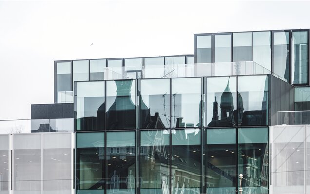 Modernes Bürogebäude mit Glasfassade Glasfassade mit Spiegelung historischer Architektur