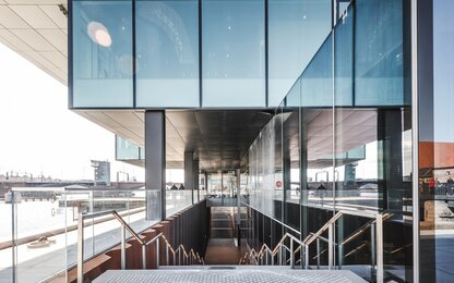 Moderner Eingangsbereich mit Glas und Treppe Moderner Gebäudeeingang mit Treppe