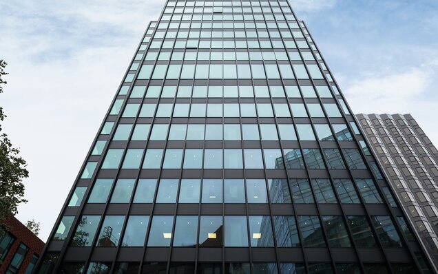 Moderne Glasfassade eines Bürohochhauses Hohe Glasfassade mit reflektierenden Fenstern