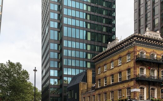 The Albert Altbau in London zwischen Wolkenkratzern The Albert Altbau mit Balkonen und Glasfassaden