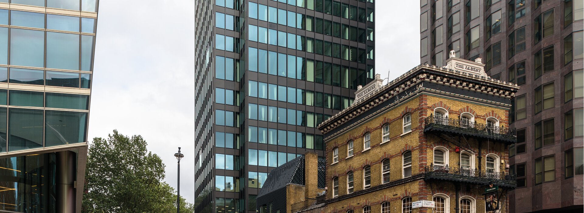 The Albert Altbau in London zwischen Wolkenkratzern The Albert Altbau mit Balkonen und Glasfassaden