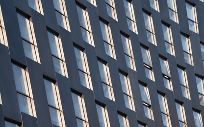 Moderne Gebäudefassade mit geometrischen Fenstern Fassade mit geometrisch angeordneten Fenstern
