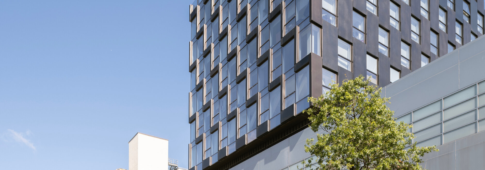 Modernes Hochhaus mit Glasfassade Modernes Hochhaus bei klarem Himmel
