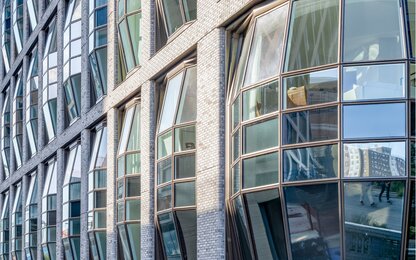 Moderne gebogene Glasfassade mit Ziegeln Gebogene Glasfassade mit Ziegelsteinverkleidung