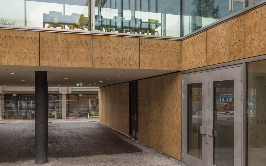Moderner Eingangsbereich mit Holz und Glas Gebäudeeingang mit Glas und Holz