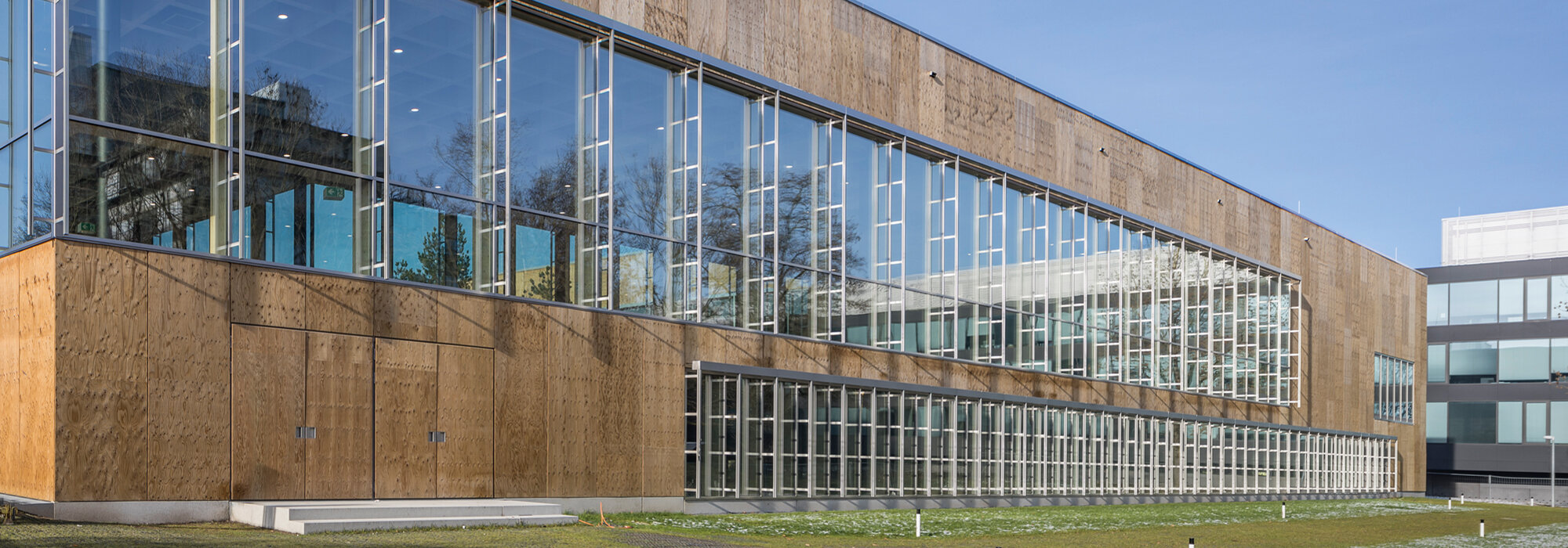 Moderne Glas-Holzfassade mit Eingangstüren Glasfassade mit Holz und Türen