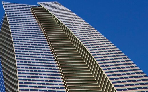 Modernes Hochhaus mit geschwungener Glasfassade Hochhaus mit Glasfassade und blauem Himmel