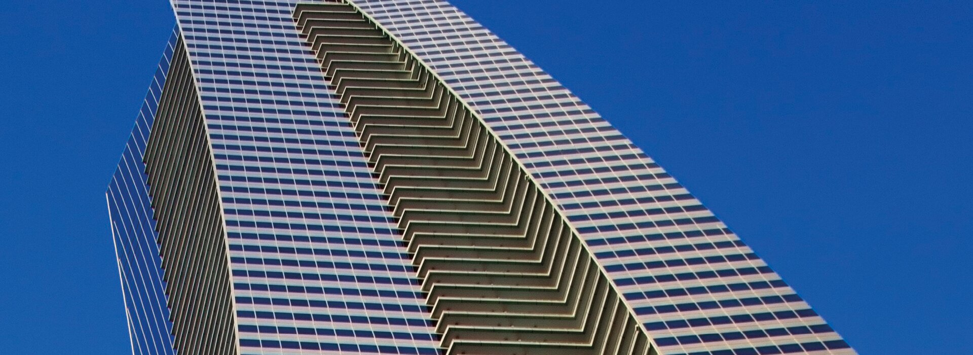 Modernes Hochhaus mit geschwungener Glasfassade Hochhaus mit Glasfassade und blauem Himmel