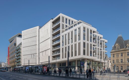 Royal Hamilius London, modernes Gebäude mit Straßenbahn und Haltestelle Modernes Gebäude mit Straßenbahn und Menschen