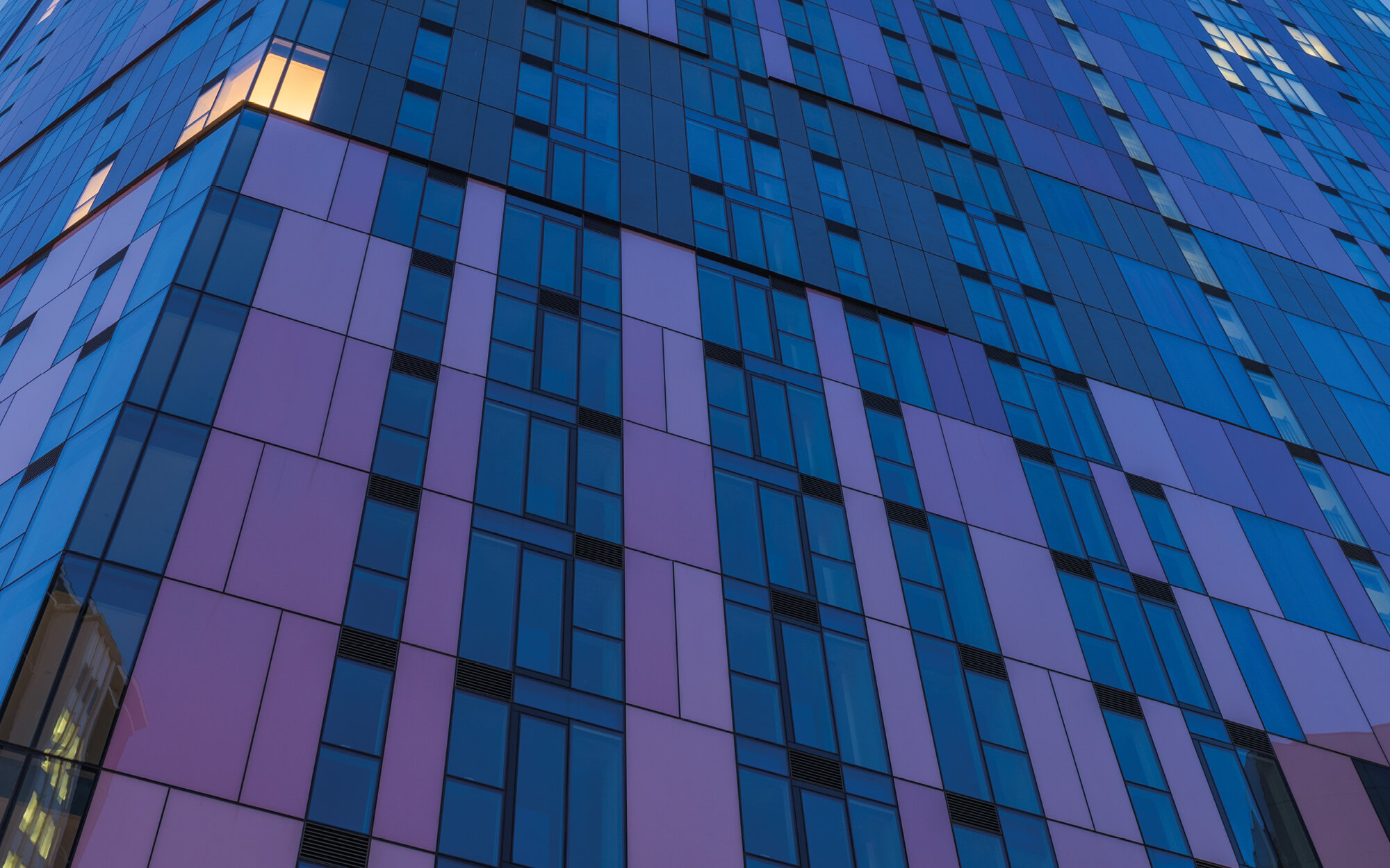 Moderne Glasfassade Hochhaus bei Dämmerung Moderne Glasfassade mit blau-violetten Paneelen