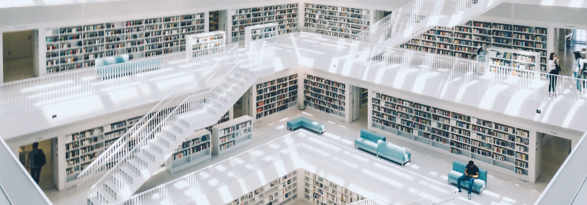 Moderne weiße Bibliothek mit Treppen und Regalen Moderne Bibliothek mit Treppen und Büchern