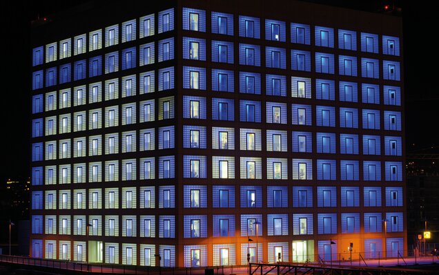Modernes Bürogebäude mit beleuchteten Fenstern nachts Beleuchtetes Bürogebäude bei Nacht